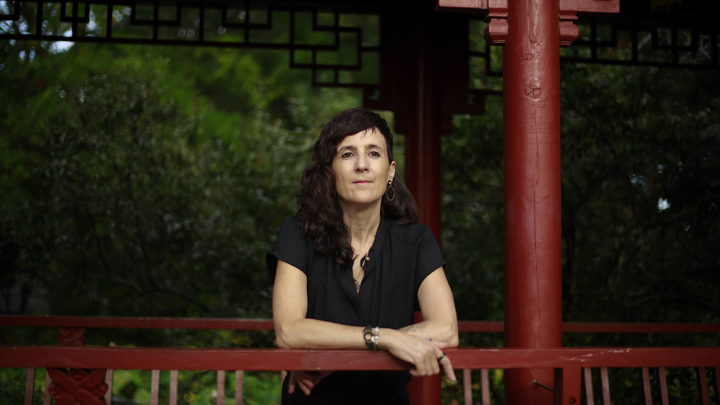 Julie Gazard, accoudée à une rambarde rouge au Jardin de Chine.